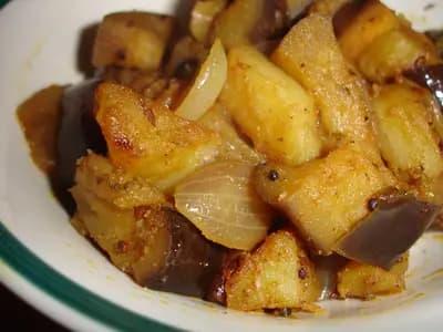 Golden fried potato cubes coated with cilantro and spices served in a white bowl