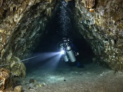 A technical diver following a guideline in a flooded cave