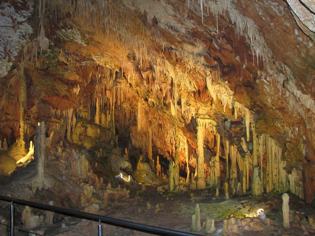 A cave diver following a guideline through a submerged limestone cave passage