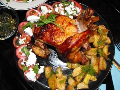 Sliced oven-roasted chicken shawarma with crispy caramelized edges, served in warm pita with tahini sauce and fresh vegetables