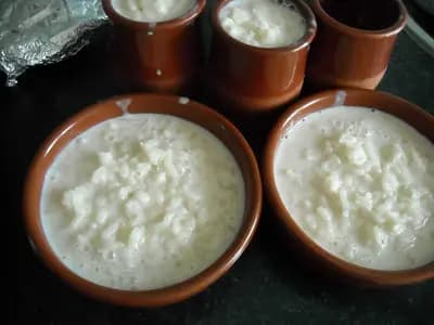 A bowl of creamy cottage cheese with visible curds, topped with berries and a drizzle of honey