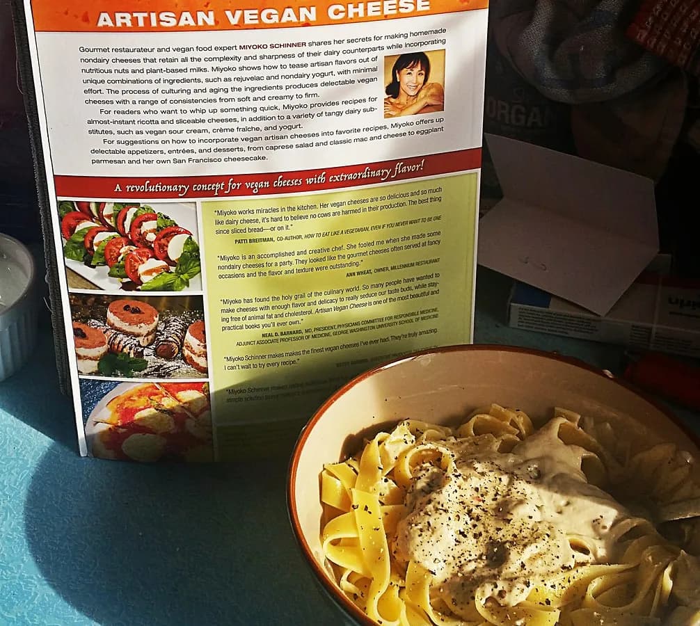 A plate of fettuccine coated in silky cashew cream sauce with cracked black pepper and lemon zest