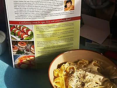 A plate of fettuccine coated in silky cashew cream sauce with cracked black pepper and lemon zest