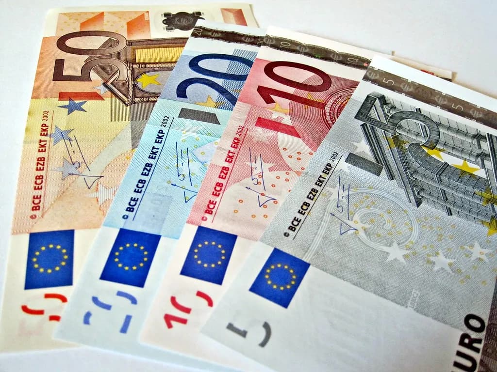 Dollar and euro currencies beside foreign-exchange market charts