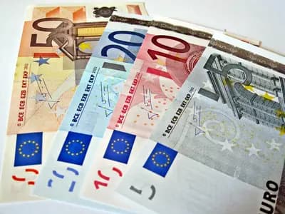 Dollar and euro currencies beside foreign-exchange market charts