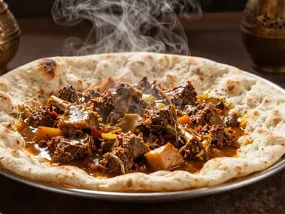 Lamb and vegetable stew poured over torn flatbread