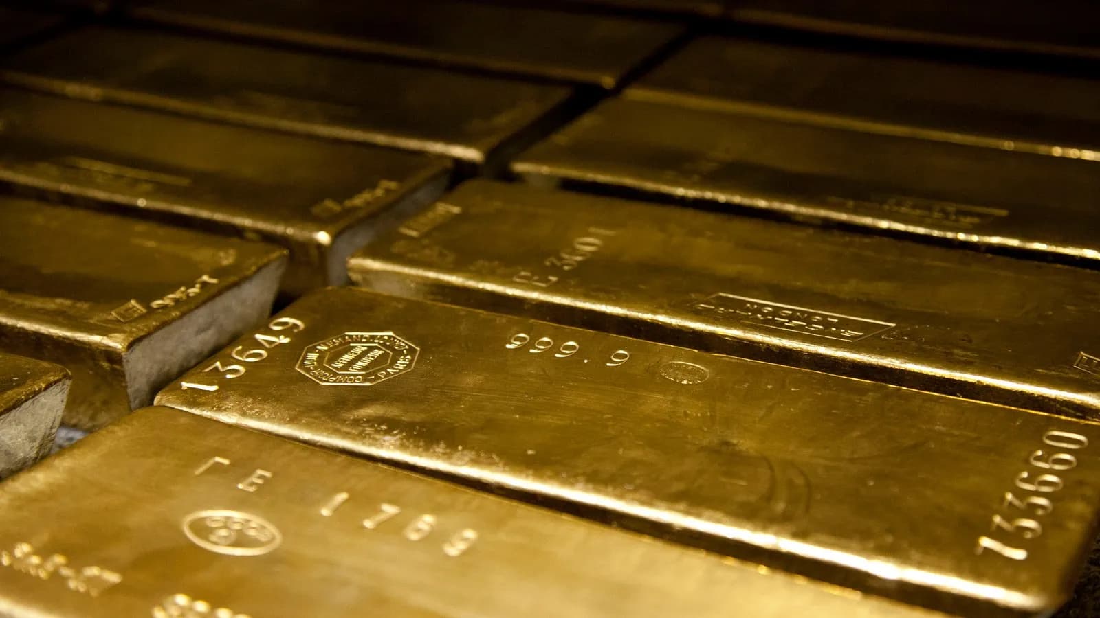 Four hundred ounce gold bars stamped 999.9 fine, stacked in a vault