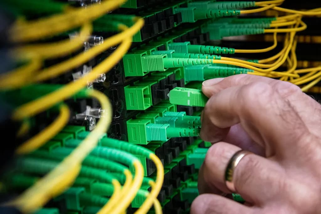 A technician walking between illuminated server racks in a large cloud data center