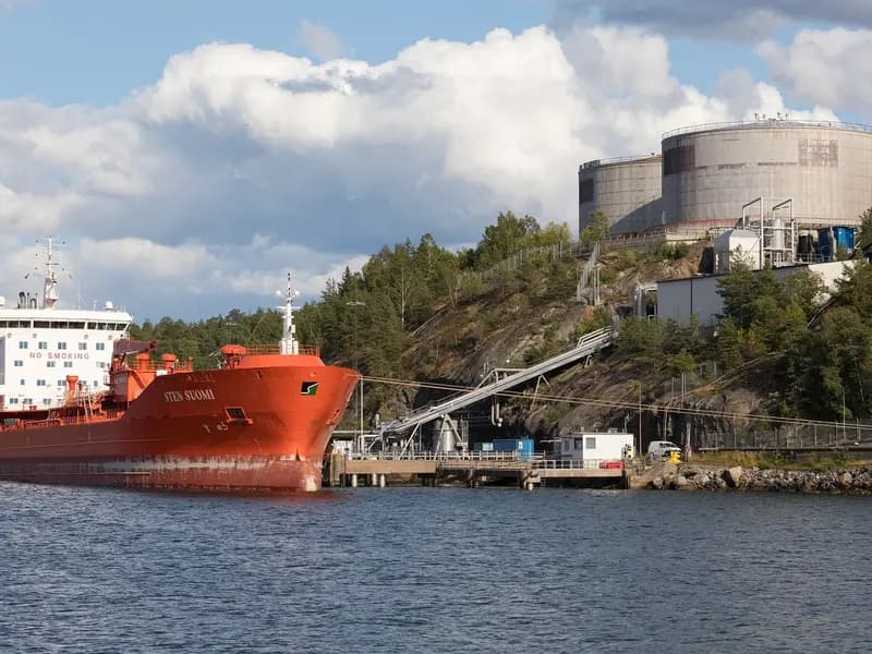 The tanker Sten Suomi berthed at a fuel depot outside Stockholm, with storage tanks on the hillside behind. The vessel struck this week was crossing the Strait of Hormuz