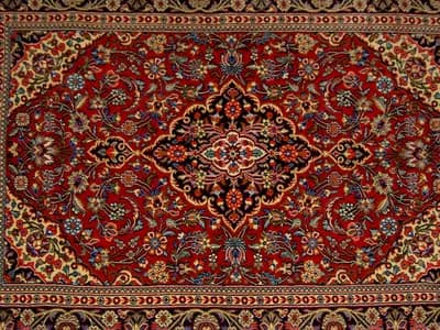 The front of a hand-knotted Qom carpet from Iran with a central medallion; the article explains what the back would show