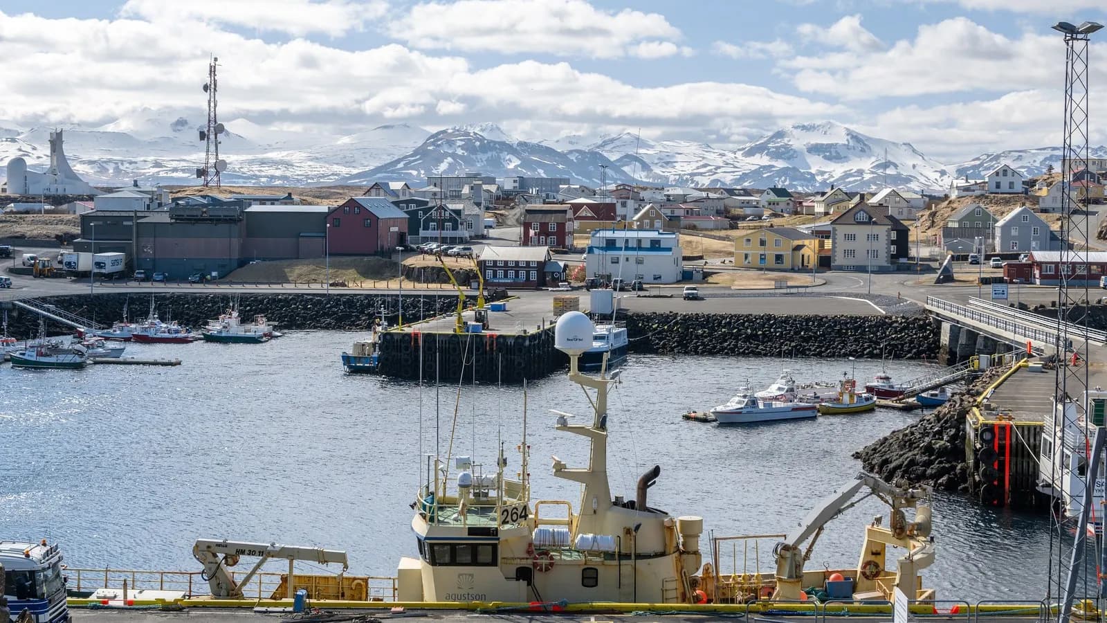 Fishing vessels tied up in the harbour at Stykkisholmur in western Iceland, with snow still on the mountains behind
