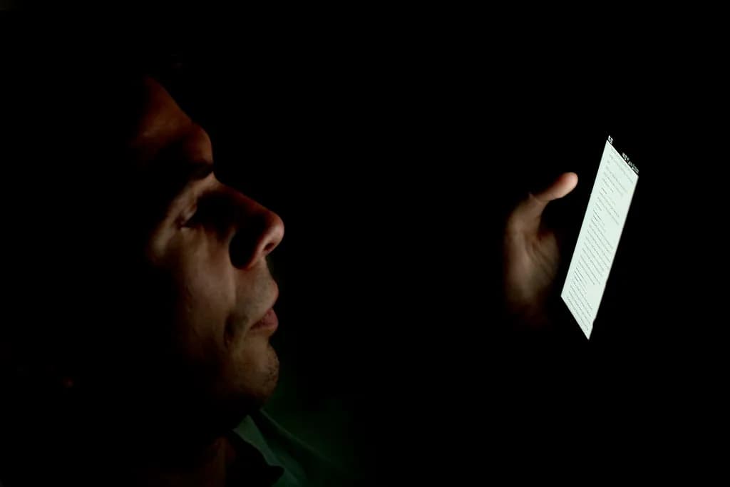 A person holding a smartphone with a glowing voice assistant interface on screen