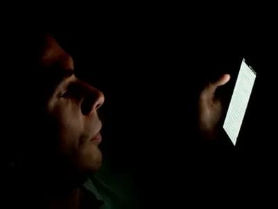 A person holding a smartphone with a glowing voice assistant interface on screen