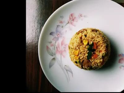 Platter of lamb kabsa with golden basmati rice, tender lamb pieces, toasted pine nuts, raisins, and warm whole spices, traditional Saudi Arabian dish