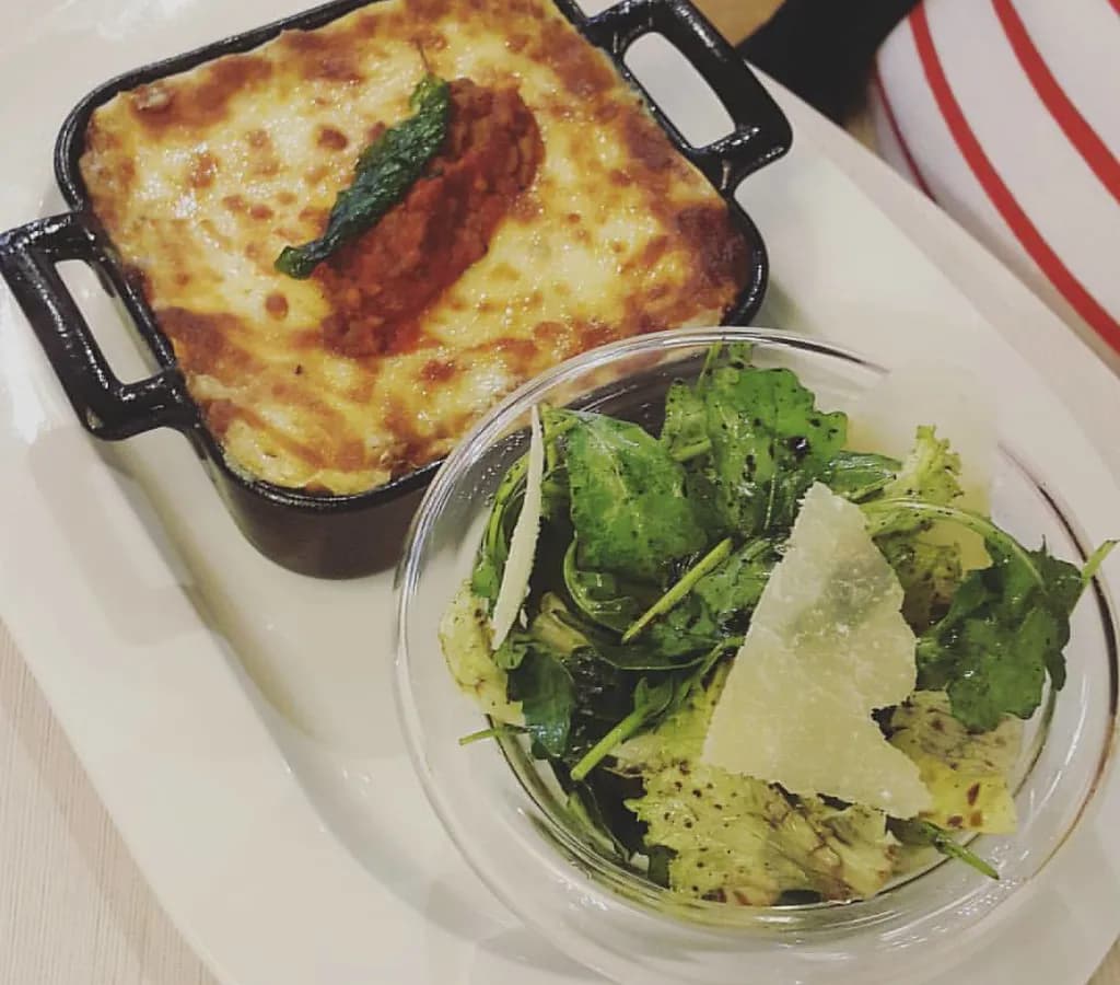 Baked lasagna al forno with golden top showing layers of pasta, ragù, and béchamel