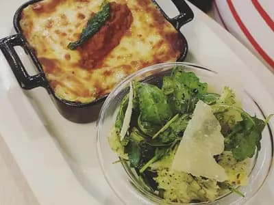 Baked lasagna al forno with golden top showing layers of pasta, ragù, and béchamel