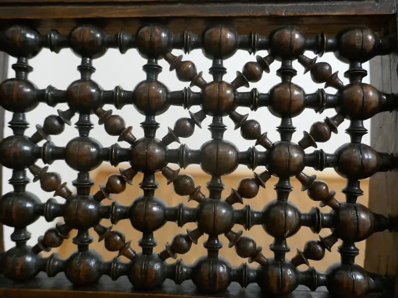 A turned wood mashrabiya screen with carved surround