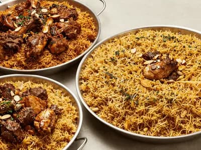 Platters of spiced rice dishes set out together on a table
