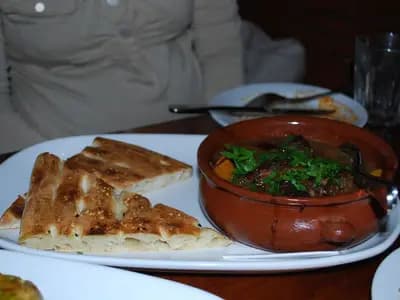 Traditional Moroccan chicken tagine with tender chicken, preserved lemon, green olives, and aromatic spices served over fluffy couscous