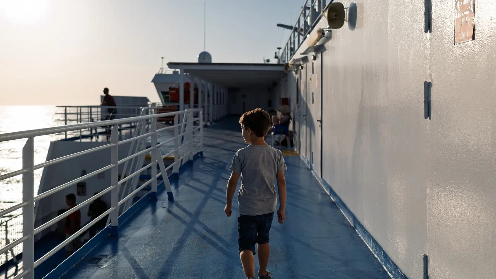 A passenger on the open deck of the ferry Blue Star Myconos crossing the Icarian Sea in Greece, September 2024