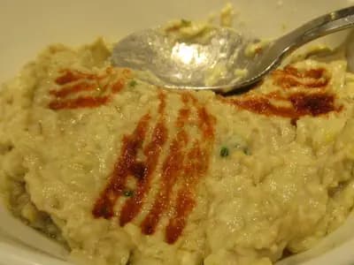 A creamy bowl of moutabal dip drizzled with olive oil and garnished with paprika and parsley