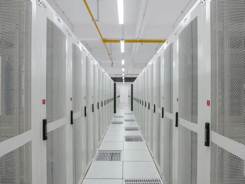 An aisle between rows of server racks in a data centre