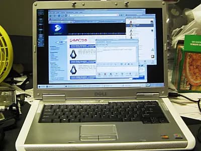 A laptop screen glowing in a dim room, displaying a conversational AI chat interface mid-response.