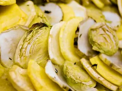 Arranged accordion-style ratatouille vegetables baked golden with tomato piperade