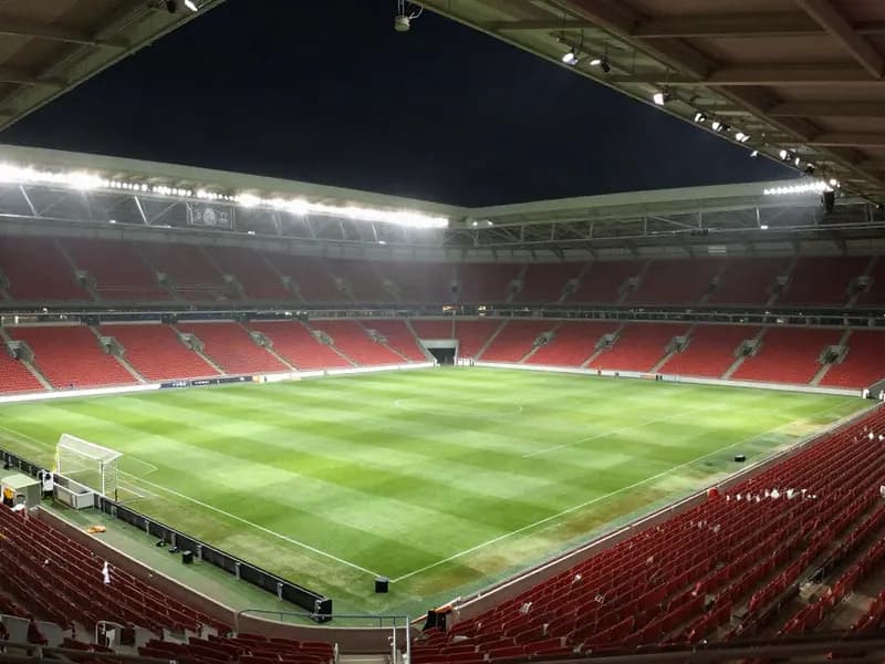Editorial illustration of an empty floodlit football stadium at night