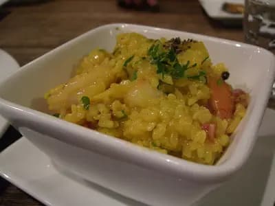 Saffron-yellow paella with shrimp, mussels, and clams in a traditional pan