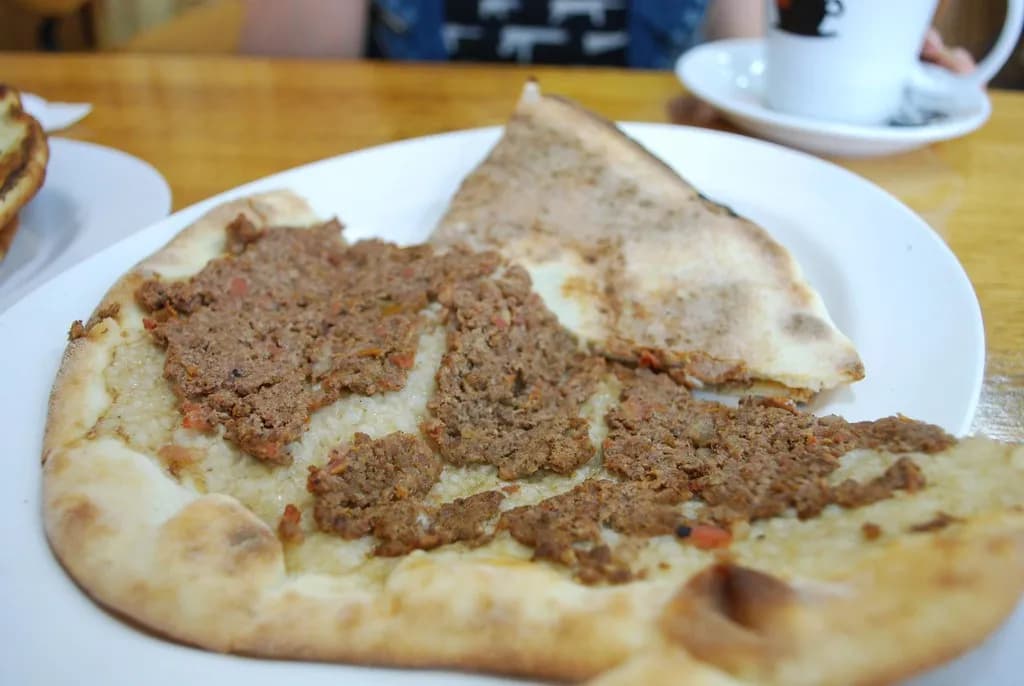 Small open-topped Lebanese meat pies on a baking tray