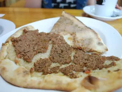 Small open-topped Lebanese meat pies on a baking tray