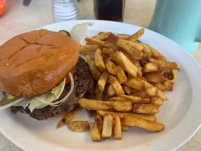 A stacked smash burger with two thin, deeply caramelized crispy-edged beef patties and melted cheese on a toasted bun