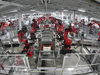 Electric vehicles moving through a highly automated factory assembly line
