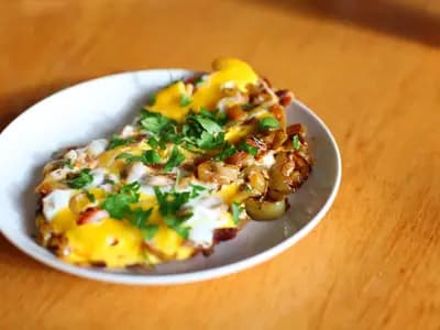 Skillet of Turkish menemen with scrambled eggs, diced tomatoes and peppers, garnished with fresh parsley and red pepper flakes