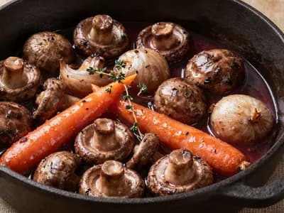 A cast iron pot of mushroom bourguignon in red wine sauce