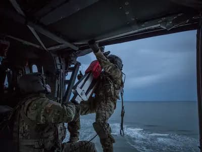 A medical evacuation helicopter flying low over open ocean near a dive boat