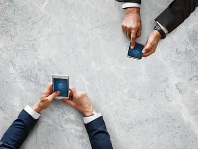 A small group of friends laughing together while sharing photos on a phone