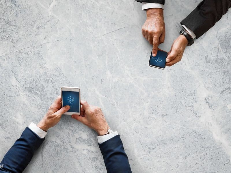 A small group of friends laughing together while sharing photos on a phone