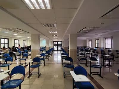 Spaced individual desks laid out in an examination hall