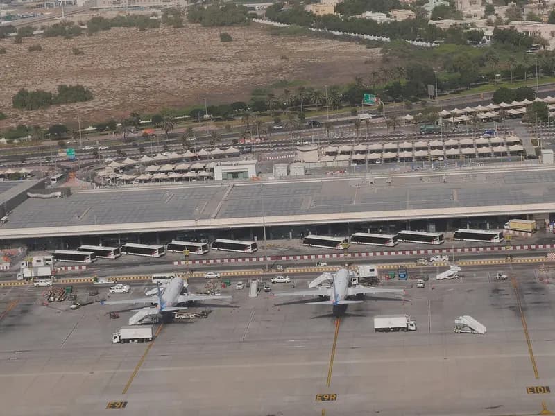 Aircraft parked at stands on the Terminal 2 apron at Dubai International Airport with the long terminal building and desert scrub behind, photographed on 24 October 2024, a file photograph of the airport and not of this winter's schedules