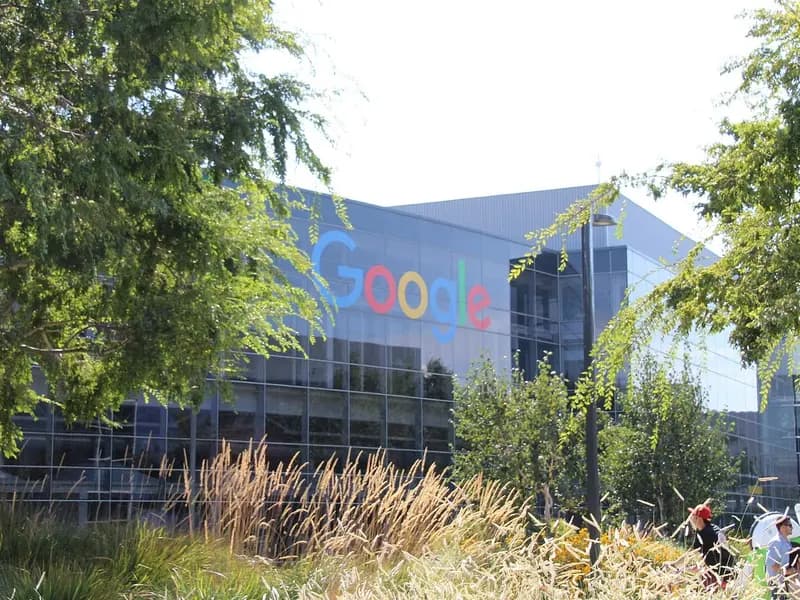 A glass-fronted Google office building with its colourful sign, seen through trees and grasses outside the company's headquarters in Mountain View, California, photographed on 12 August 2017, a file photograph of the campus and not of Wednesday's results