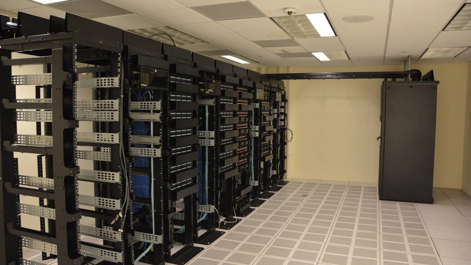Rows of server racks in a data centre, lit from within, of the kind that trains and runs large AI models