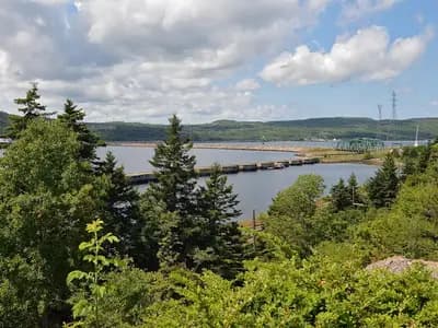 The Strait of Canso at Port Hastings in Nova Scotia, with a causeway and green hills under a blue sky, photographed on 26 July 2022, a file photograph of the strait and not of the planned data centre site