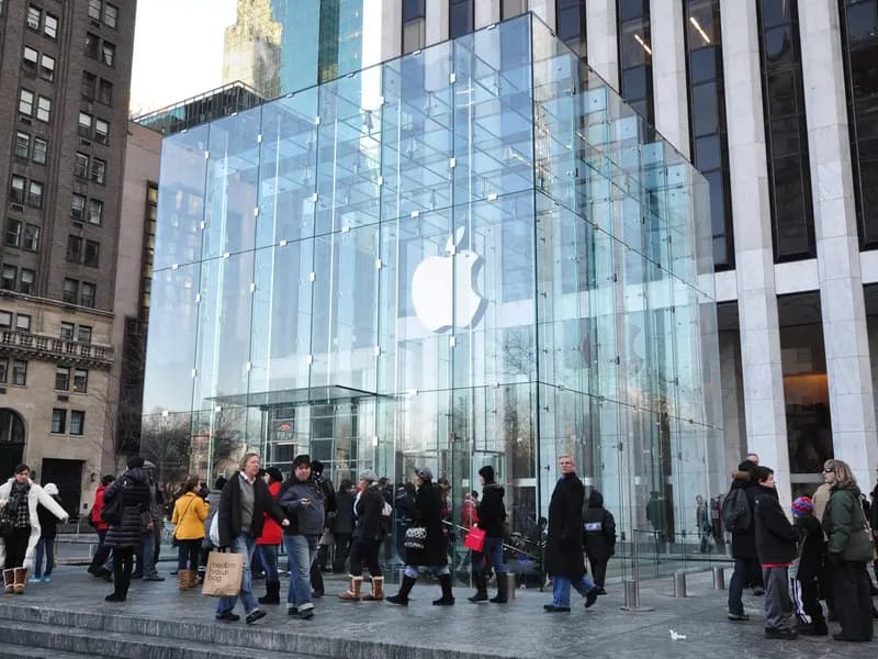 The glass cube of Apple's Fifth Avenue store in New York, with shoppers on the plaza in front of it