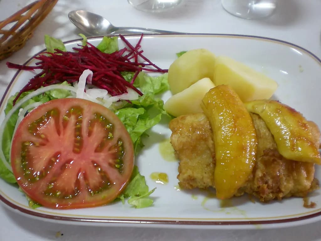 A platter of fish and rice over flatbread with a pale sauce