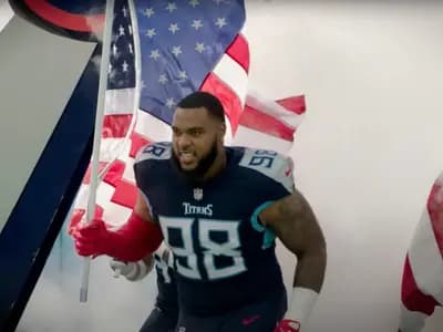 Tennessee Titans defensive tackle Jeffery Simmons, number 98 in a navy jersey, running onto the field at Nissan Stadium through smoke carrying an American flag before a game against the New York Giants on 11 September 2022, a file image of Simmons with his former team and not of the trade or of him in a Bears uniform