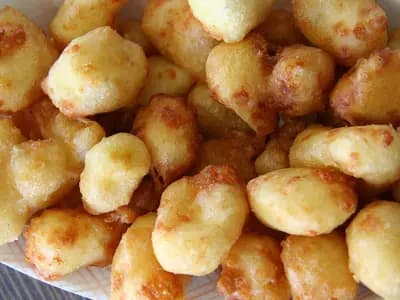A paper tray of golden beer-battered fried cheese curds, photographed on 17 June 2010 at the Gopher Count community festival in Viola, Minnesota, a file photograph of the dish and not of the Culver's curds
