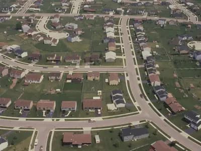 An aerial view of an American residential subdivision of detached houses on curving streets