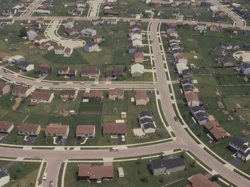 An aerial view of an American residential subdivision of detached houses on curving streets
